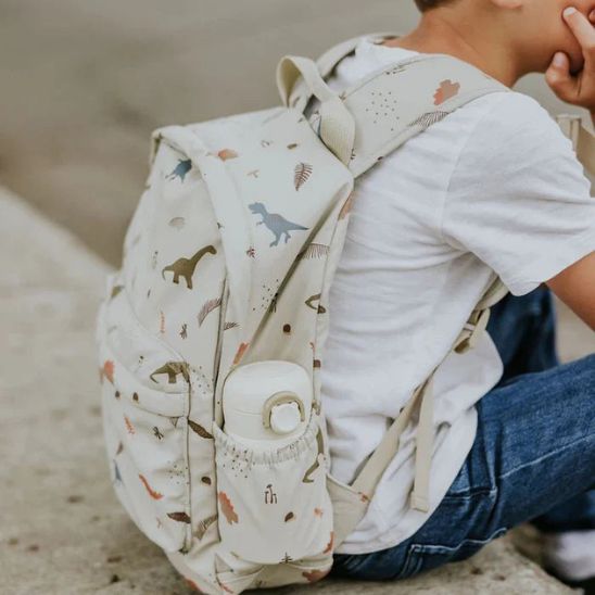 jeune-garcon-assit-avec-son-sac-a-dos-dino-world
